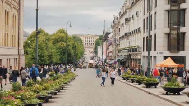 Oslo, Noruega, julio de 2018: Una vista a lo largo de la calle Karl Johans hacia el Palacio Real. Una calle hermosa y concurrida con un montón de cafés y tiendas, un lugar popular entre los turistas — Vídeos de Stock