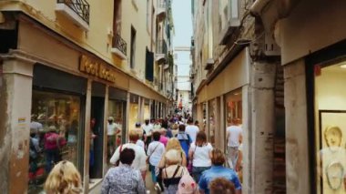 Venedik, İtalya, Haziran 2017: Turist Venedik cadde boyunca Hediyelik eşya mağazaları yürüyor ve butikler markalı. Onlar aydınlık windows gidin. Turizm ve İtalya'da alışveriş