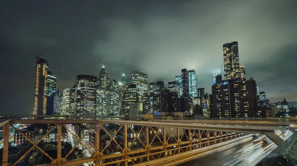 Драматические грозовые тучи над нижним Манхэттеном и ночное движение автомобилей вдоль Бруклинского моста на переднем плане — стоковое фото