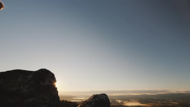 Активная женщина поднимается на вершину горы, любуется красивыми пейзажами Норвегии — стоковое видео