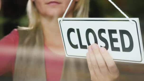 A store worker rubs the glass under the plate Open. — Stock Video