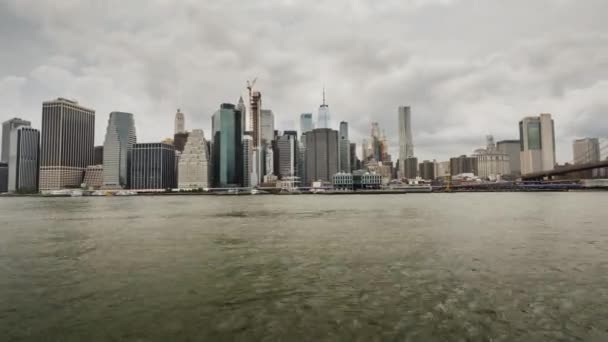 Panorama de la ciudad de Nueva York, el tráfico de barcos en el río con vistas al distrito financiero de Manhattan. La cámara gira hacia el puente de Brooklyn — Vídeos de Stock