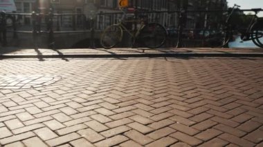 Amsterdam kanal üzerinde köprü üzerinde bisiklet trafik. Gün batımından önce