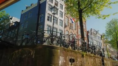 Köprünün altında Amsterdam kanal genelinde yüzme. Şehrin eski kesiminde güzel mimari görünümünü. Tekne gezisinde kanallar, Hollanda'da turizm.