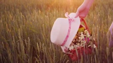 Doğada - yaz yürüyüş kadın bir sepet çiçek ve şapkasını elinde taşır