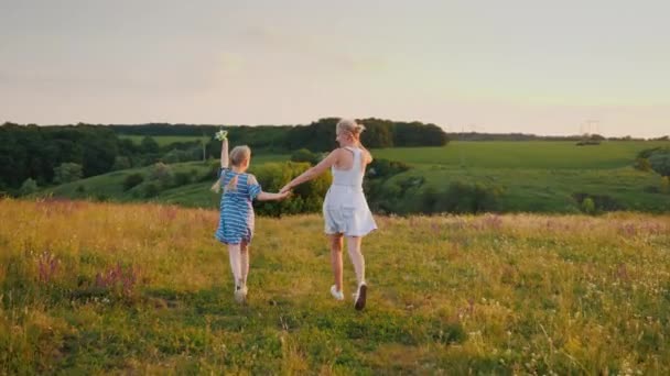 Une jeune femme avec sa fille lance deux cerfs-volants, s'amuse et profite de vacances actives — Video