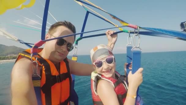 Šťastný otec a dcera jsou létání na parasailing. Otec bere selfie s holkou, aktivní dovolená s dítětem — Stock video
