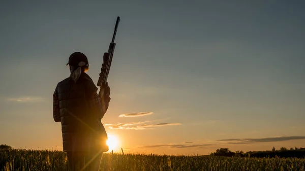 Deporte de tiro y caza mujer con un rifle al atardecer — Foto de Stock