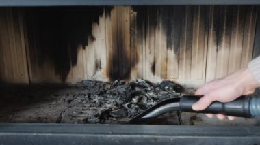 Bir adam küller içinde bir vakum cleaner, yakın çekim ile şömine temizler