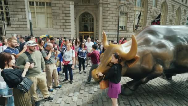 New York, USA, ottobre 2018: Molte persone cercano di scattare foto accanto alla statua di un toro carica — Video Stock