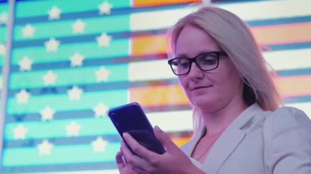 Mulher Negócios Usa Smartphone Fundo Uma Grande Bandeira Americana Famosa — Vídeo de Stock