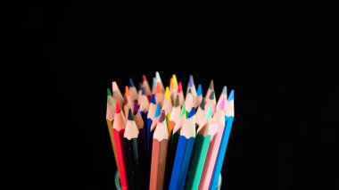 Siyah bir zemin üzerine parlak çok renkli kalem kümesi