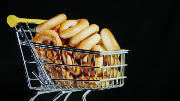 Cesta de la compra con rosquillas sobre fondo negro — Vídeos de Stock