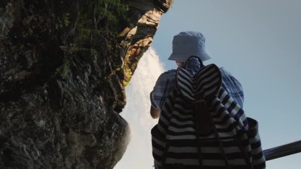 Woman Standing Waterfall Steinsdalsfossen Takes Photo Hangs Rock Majestic Nature — Stock Video