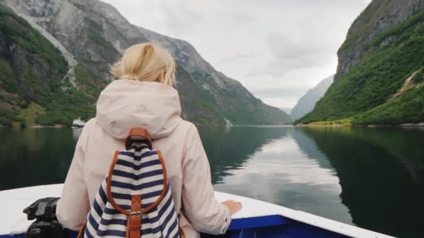 Un viaje fascinante por los fiordos de Noruega. Mujer de pie en la proa de un crucero — Vídeos de Stock
