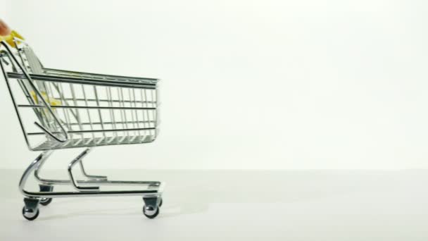 Rukou kupce tlačí malou nákupní košík vpřed. Čekání na nákupy — Stock video
