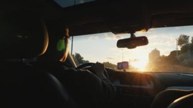 Genç sürücü bir araba. Gün batımı arka görünüm