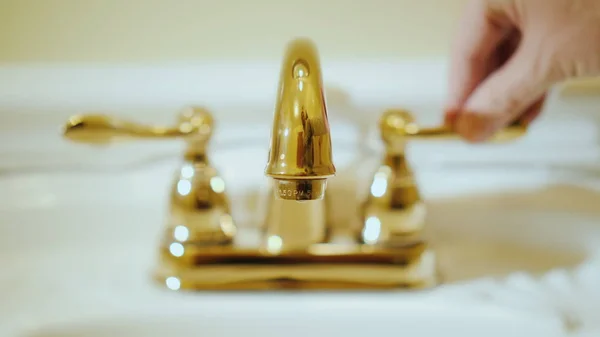 La mano apre l'acqua nel rubinetto con acqua. Approvvigionamento idrico e impianti idraulici di lusso — Foto Stock