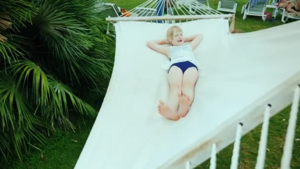 Twee vriendinnen van de koele meisjes spelen op de speelplaats in een hangmat in een exotische resort — Stockvideo