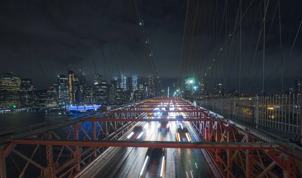 布鲁克林大桥上的交通车辆在纽约夜晚轮廓的背景下， — 图库照片
