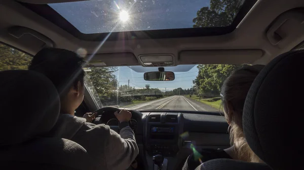 Parejas jóvenes viajando en un coche en los suburbios de EE.UU. — Foto de Stock