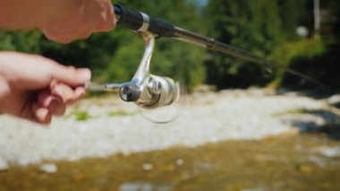 Bir olta fishermans yardım çerçevesinde bir küçük dağ nehrinde Balık tutma