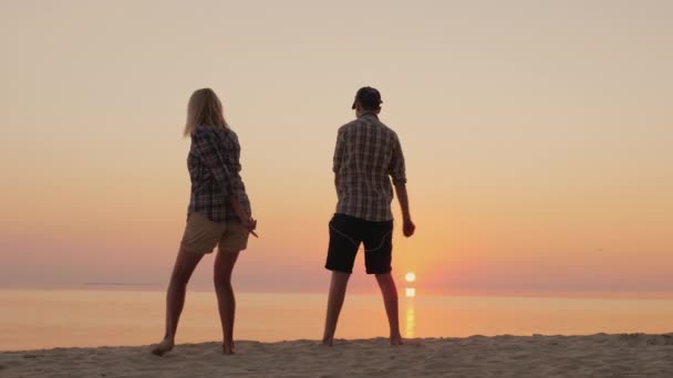 Una mujer y su hijo adolescente bailan juntos un baile divertido en la playa. Aprender movimiento de baile de moda — Vídeos de Stock