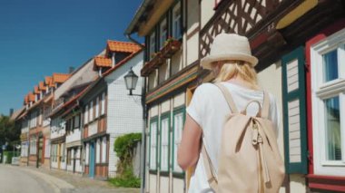 Elinde bir telefon ile bir turist bir Avrupa kentinin güzel sokak boyunca yürüyor. Arka görünüm