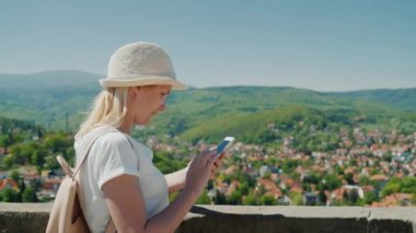 Her zaman bağlı. Almanya güzel bir kasaba arka planda bir akıllı telefon ile bir kadın turist.