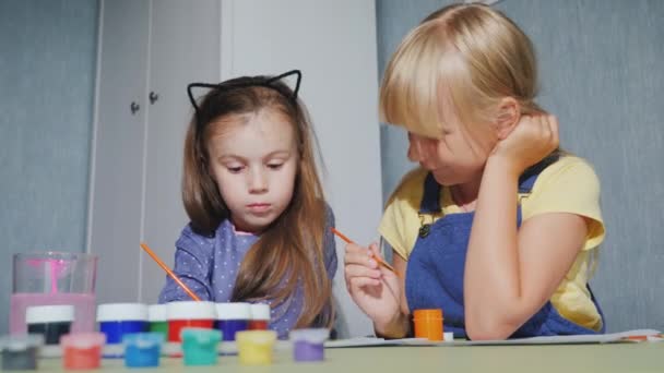Dvě dívky sedí vedle sebe, malovat a akvarel — Stock video