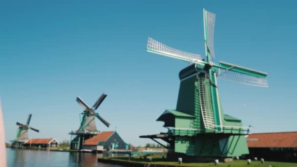 Steadicam shot: vrouw neemt foto's van oude windmolens in Zaans schans — Stockvideo