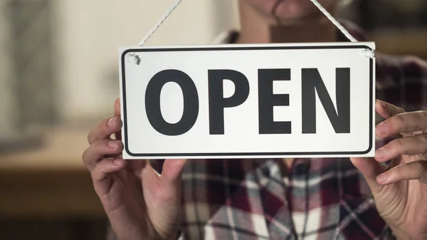 Womens hands at the plate Open on the glass door of the store