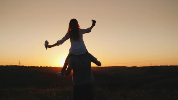 Щасливий батько грає зі своєю дочкою на заході сонця. відео — стокове відео