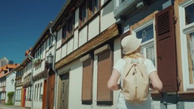 Arka görünümü: bir kadın turist şehrin güzel ıssız cadde boyunca bir yürüyüş sahiptir.