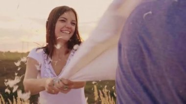 Gençler eğleniyor. Bir kadın bir arkadaşıyla yastığını çırpıyor, tüyler uçuşuyor. Yastıklara karşı savaş, gençlik enerjisi