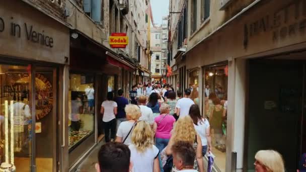 ヴェネツィア、イタリア、2017年6月:土産物店やブランドブティックの近くにヴェネツィア通りに沿って歩きます。彼らは明るい窓に沿って行く。イタリアの観光とショッピング — ストック動画