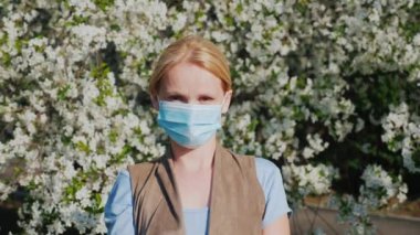 Çiçekli ağaçların arka planına karşı gazlı bez bandajı olan bir adam. Bahar çiçekli kavramı sırasında Alerji