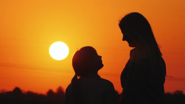 Anne ve kızı birlikte şehir ve turuncu gökyüzü üzerinde güzel gün batımı bakmak — Stok video
