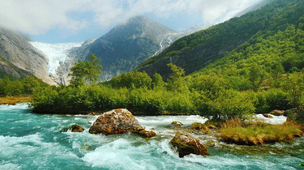 Briksdalgletscher mit einem Gebirgsfluss im Vordergrund. Die erstaunliche Natur Norwegens — Stockfoto