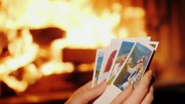 Kadın Tatil fotoğraflarına bakmaktan. İçinde belgili tanımlık fotoğraf, genç bir çift dinleniyor dağlarda, çerçevede sadece ellerini şömine arka plan üzerinde gördüğünüz