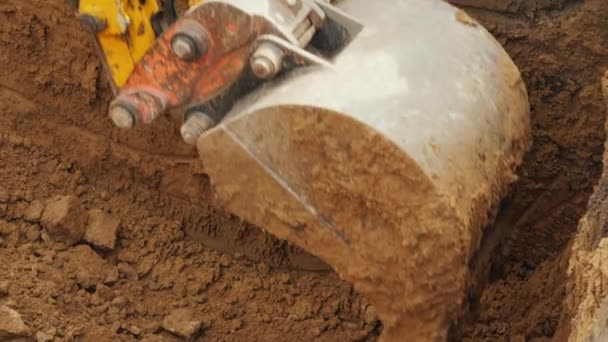 The bucket of a powerful excavator removes soil from the pit, lay the pipeline — Stock Video