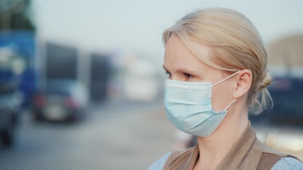 Une femme dans un bandage de gaze protectrice se tient près d'un chemin de terre poussiéreux. Problèmes environnementaux — Video