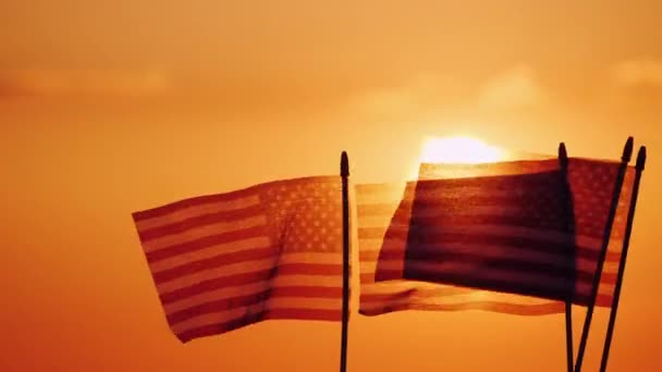 Plusieurs drapeaux américains contre le soleil couchant et le ciel orange — Video