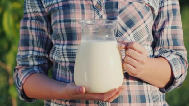 Een boer houdt een kruik melk. Gezond biologisch voedsel — Stockvideo