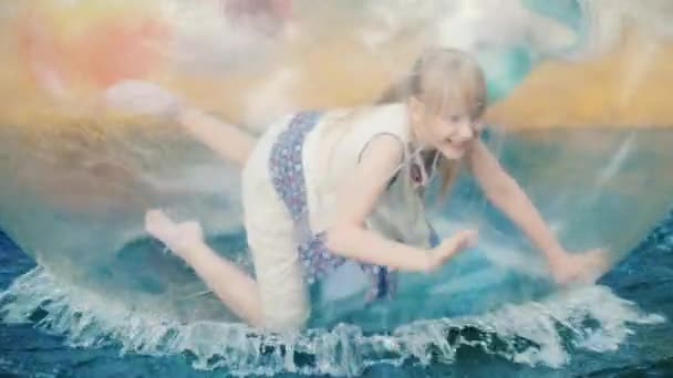 Menina se divertir dentro da bola que nada na piscina férias de verão — Vídeo de Stock