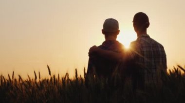 Gün batımının arka planında sarılan iki genç adam, ufku dört gözle bekliyorlar.