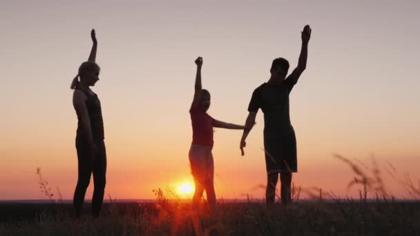 Junge Familie mit Kind macht Übungen an einem schönen Ort bei Sonnenuntergang — Stockvideo