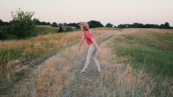 Landelijk meisje op een landweg doet een acrobatische stunt wiel — Stockvideo