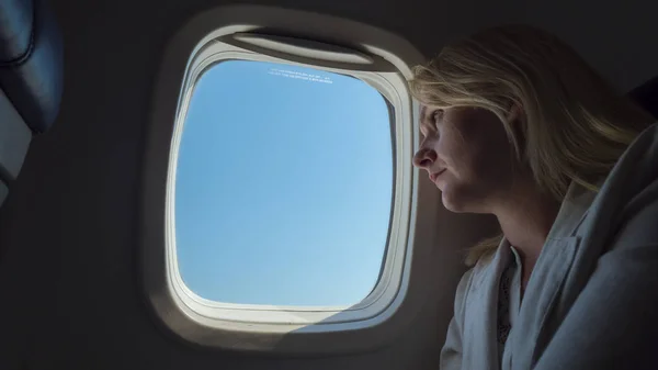 De passagier kijkt uit het raam, reizen in een vliegtuig — Stockfoto