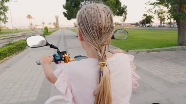 一个带着非洲辫子的孩子骑着摩托车，后视镜。快乐而积极的娱乐活动 — 图库视频影像